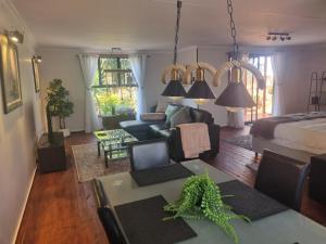 Sala de estar con cama, sofá y mesa en Meraki Country Manor, en Lanseria