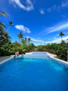 a person sitting in a swimming pool at D ARC Leisure Home By The Sea in Panglao Island