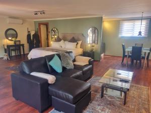 1 dormitorio con cama, sofá y mesa en Meraki Country Manor, en Lanseria