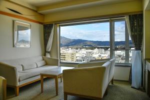 a living room with a couch and a large window at The Gran Resort Elegante Kyoto in Kyoto