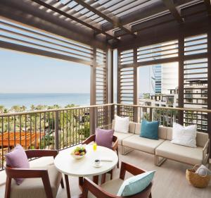 a living room with a balcony with a table and chairs at Jumeirah Al Naseem Dubai in Dubai