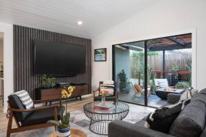 sala de estar con TV de pantalla plana y sofá en Tropical Beach Villa with Deck, Spa Walk to Ocean, en Santa Bárbara