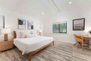 a white bedroom with a bed and a desk at Tropical Beach Villa with Deck, Spa Walk to Ocean in Santa Barbara