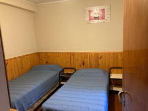 2 camas en una habitación con paneles de madera en Cirse en Río Gallegos