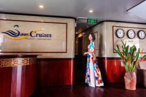 Una mujer con un vestido de pie en un escenario en Swan Cruises Halong, en Ha Long