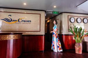 a woman in a dress standing on a stage at Swan Cruises Halong in Ha Long