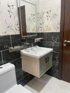 a bathroom with a sink and a toilet and a mirror at سما2 in Yanbu