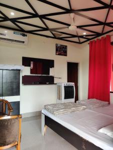 Habitación con cama y cortina roja en Kanva Farms, en Kotdwāra