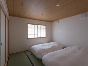 Ishikariにある古民家の宿 Soliiの窓のある部屋にベッドが2つある