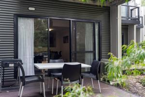 a patio with a table and chairs on a deck at Forestview Apartment Margaret River in Margaret River Town +8 photos