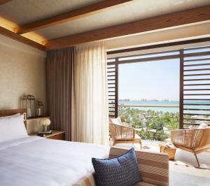 a bedroom with a bed and a large window at Jumeirah Al Naseem Dubai in Dubai