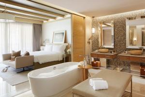 a bathroom with a bed and a tub and a bedroom at Jumeirah Al Naseem Dubai in Dubai