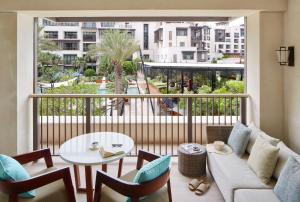 a living room with a balcony with a couch and a table at Jumeirah Al Naseem Dubai in Dubai