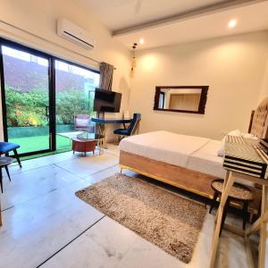 una camera con letto, scrivania e TV di Giovanni Suites a Bhopal