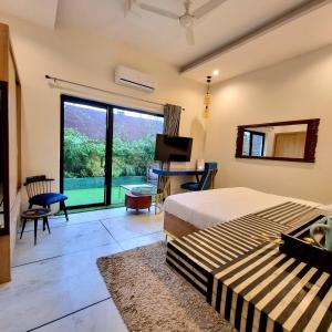 Dormitorio con cama, escritorio y TV en Giovanni Suites en Bhopal