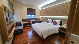una camera d'albergo con un letto e una televisione di FOX Lite Grogol Jakarta a Giacarta
