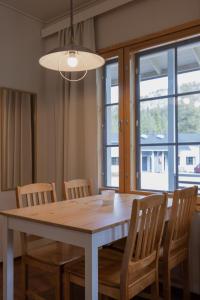 a dining room table with chairs and a large window at Sallainen Cottages in Salla