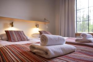 a hotel room with two beds with towels on them at Sallainen Cottages in Salla