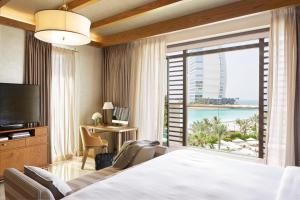 a hotel room with a bed and a large window at Jumeirah Al Naseem Dubai in Dubai