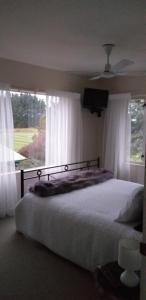 a bedroom with a bed and a large window at Seaside/Golf B n B in Christchurch