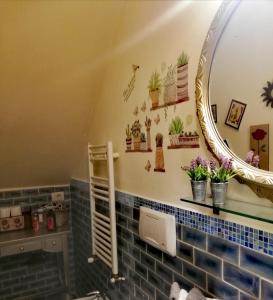 a bathroom with a mirror and plants on the wall at Il rifugio dei vinili by Casolare Isabella in Ponsacco