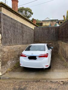 una macchina bianca parcheggiata accanto a un muro di Kitty Spain's Cottage a Mannum