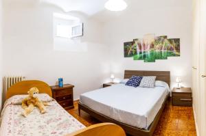 um quarto com duas camas e um urso de peluche sentado na cama em Casa la Fortezza em Porto Santo Stefano