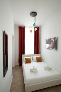 - une chambre dotée d'un lit blanc avec deux animaux rembourrés dans l'établissement DrsRome-Cavour, à Rome