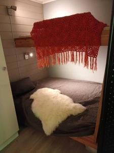 a room with a bed with a red rug on the wall at Koselig leilighet , med parkering og ski in &out. in Oppdal