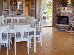 a dining room with a table and chairs and a fireplace at Holiday home Berg I Østfold in Dale