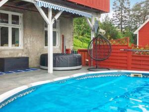 a swimming pool with a swing next to a house at Holiday home Bruvik in Bruvik