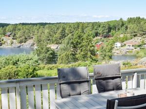 a table and chairs on a balcony with a view of a river at Holiday home Berg I Østfold in Dale