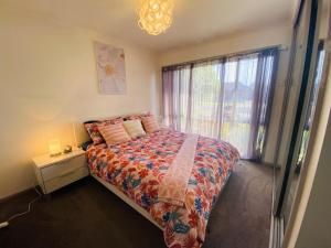 a bedroom with a bed and a window at ENTIRE HOME IN WERRIBEE,BEST POSSIBLE LOCATION YOU CAN FIND in Werribee