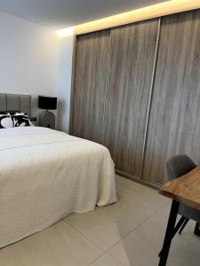 1 dormitorio con 1 cama y pared de madera en Luxury penthouse with sea view in La Cala Golf Resort, en La Cala de Mijas
