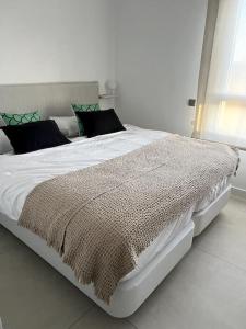 sypialnia z dużym białym łóżkiem z kocem w obiekcie Luxury penthouse with sea view in La Cala Golf Resort w mieście La Cala de Mijas