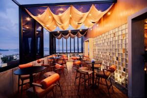 a restaurant with tables and chairs and a large window at Zoom Hotel Mulawarman in Samarinda