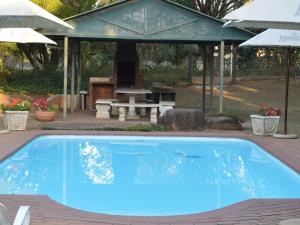 a swimming pool with a pavilion and a picnic table at Ascot Inn in Pietermaritzburg