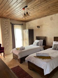 a bedroom with two beds and a wooden ceiling at UCHI Cappadocia in Uchisar