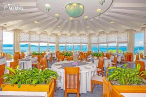 un ristorante con tavoli e sedie e l'oceano sullo sfondo di Hotel Marina a Selce