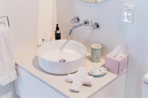 a bathroom with a sink and toiletries on a counter at Port O' Call Motel in Port Campbell