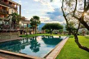 - une piscine dans un parc à côté d'un bâtiment dans l'établissement Das Panorama Designhotel, à Caldaro