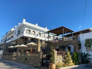 un edificio con sombrillas a un lado. en Spitalia Rooms, en Tinos