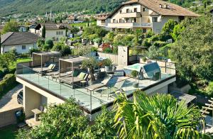 una casa con techo de cristal con sillas. en Das Panorama Designhotel, en Caldaro