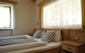 um quarto com uma cama com almofadas e uma janela em Apartments Etruska em Santa Cristina in Val Gardena