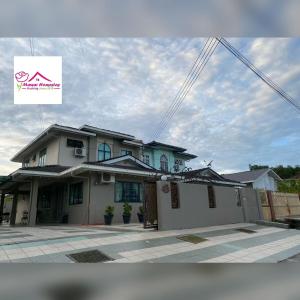 a house with a sign in front of it at MAWAR HOMESTAY KUCHING in Kuching