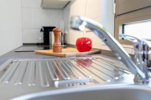 un fregadero de cocina con pimienta roja en una tabla de cortar en Appartement Champagne en Neuenstadt am Kocher