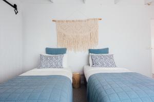 2 letti in una camera con blu e bianco di Port O' Call Motel a Port Campbell