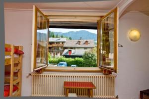 een raam in een kamer met uitzicht op een huis bij Chalet la Griotte in Villars-sur-Ollon