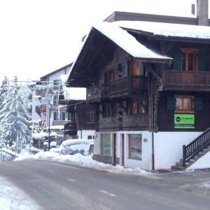a building with snow on the side of a street at Chalet la Griotte in Villars-sur-Ollon