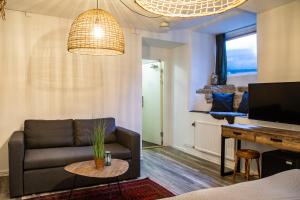 a living room with a couch and a tv at Hotell Lindgården in Visby